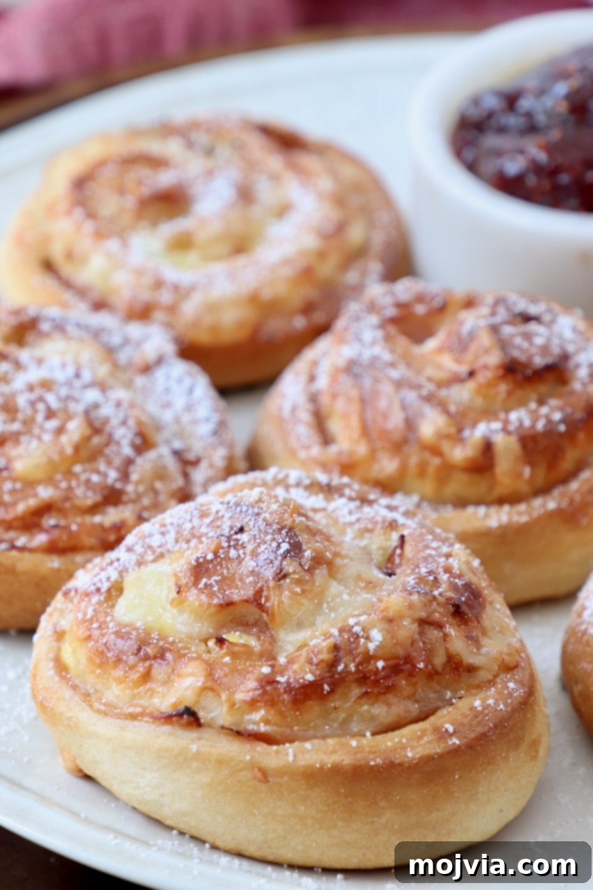 cooked monte cristo rolls on plate with a small bowl of raspberry jam