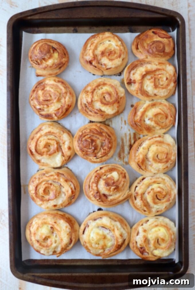 baked monte cristo rolls on parchment lined baking sheet