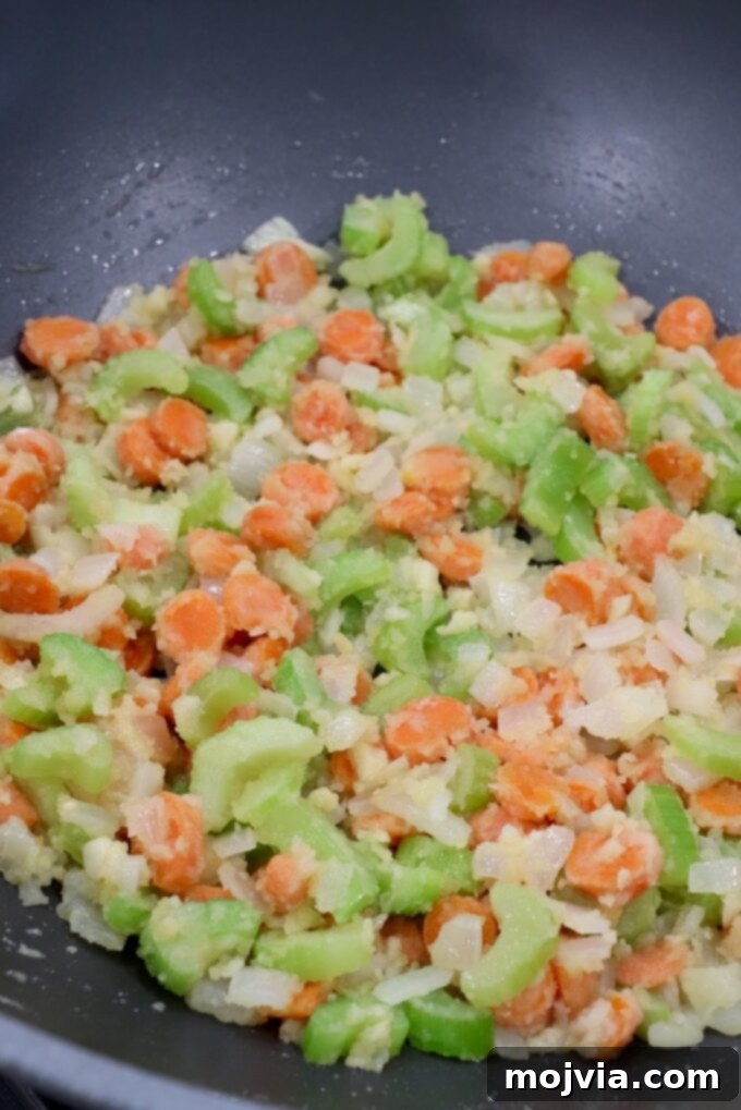 Cozy Chicken Pot Pie Soup 6 Flour fully combined with diced carrots, onions, and celery in a skillet, creating a golden roux that will thicken the rich chicken pot pie soup.