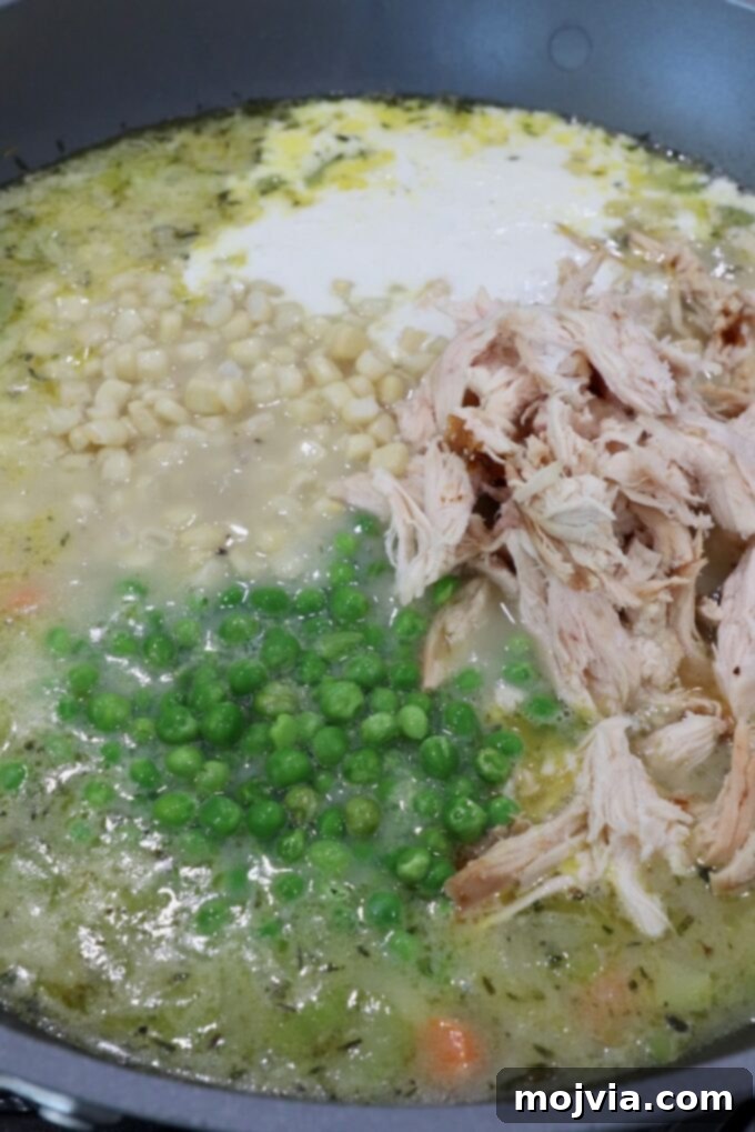 Cozy Chicken Pot Pie Soup 10 A large pot filled with creamy, rich chicken pot pie soup, loaded with tender chicken and vegetables, ready for the final touches.