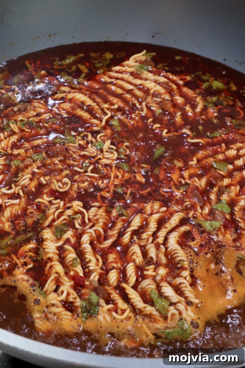 Instant ramen noodles in large pot of birria broth