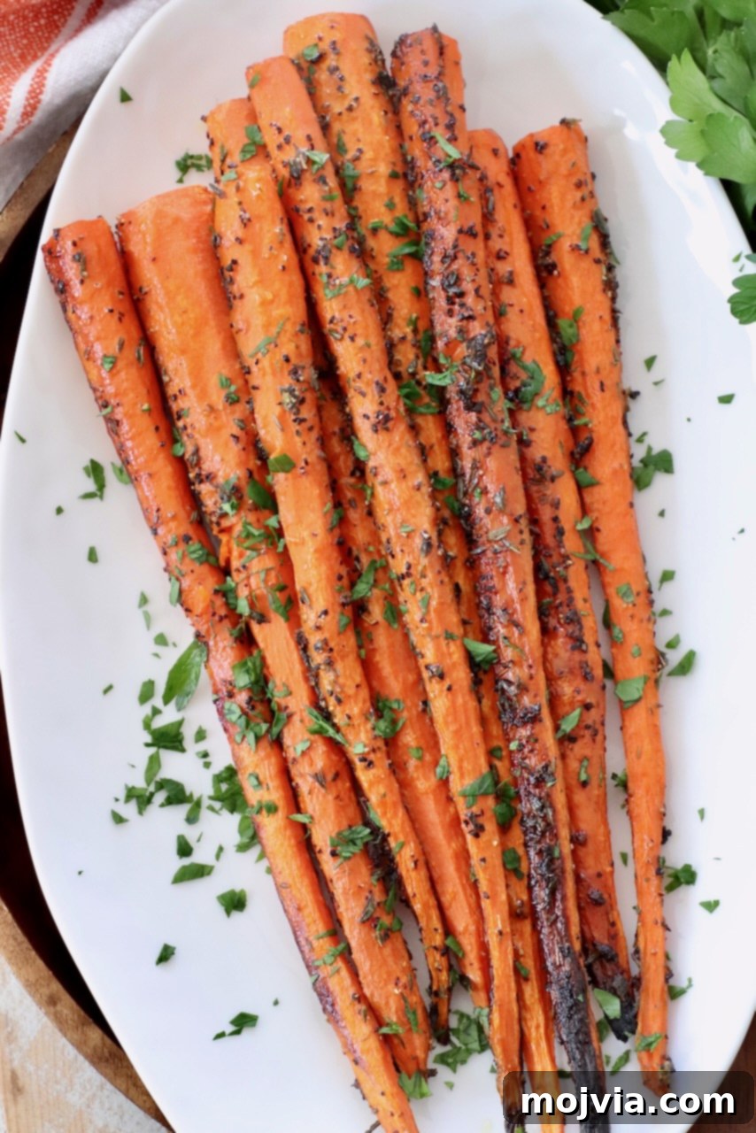 perfectly roasted carrots topped with fresh chopped parsley on a white plate