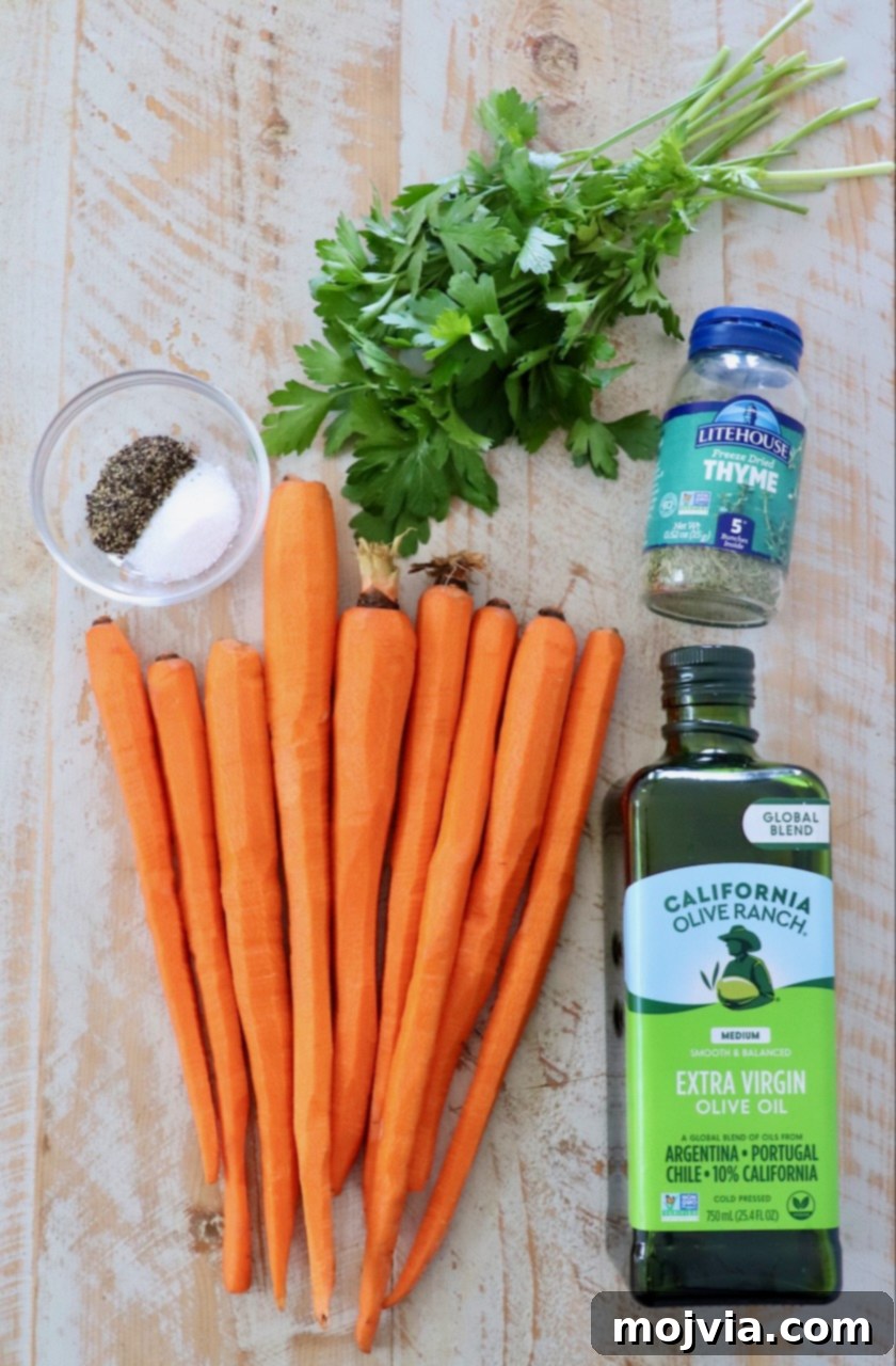 ingredients for oven roasted carrots laid out on a white wood board