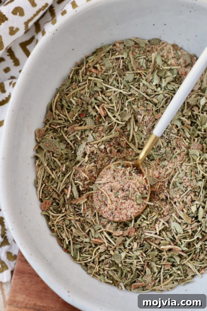 A small bowl filled with homemade turkey seasoning, accompanied by a tiny spoon, ready for use.