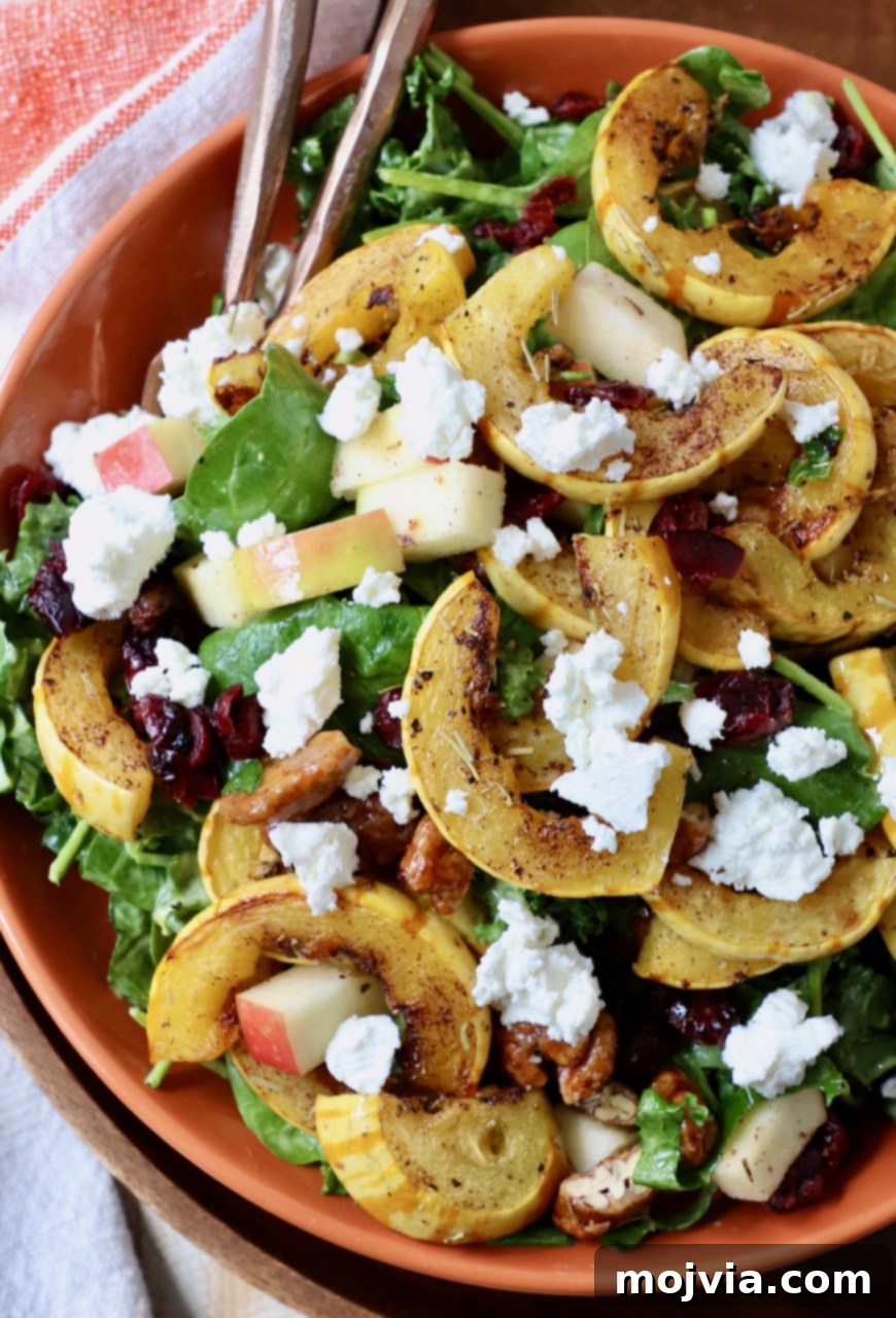 Roasted Delicata Harvest Bowl 2 salad in bowl topped with roasted strips of delicata squash and crumbled goat cheese