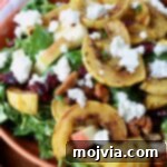 Roasted Delicata Harvest Bowl 7 salad topped with roasted delicata squash and crumbled goat cheese