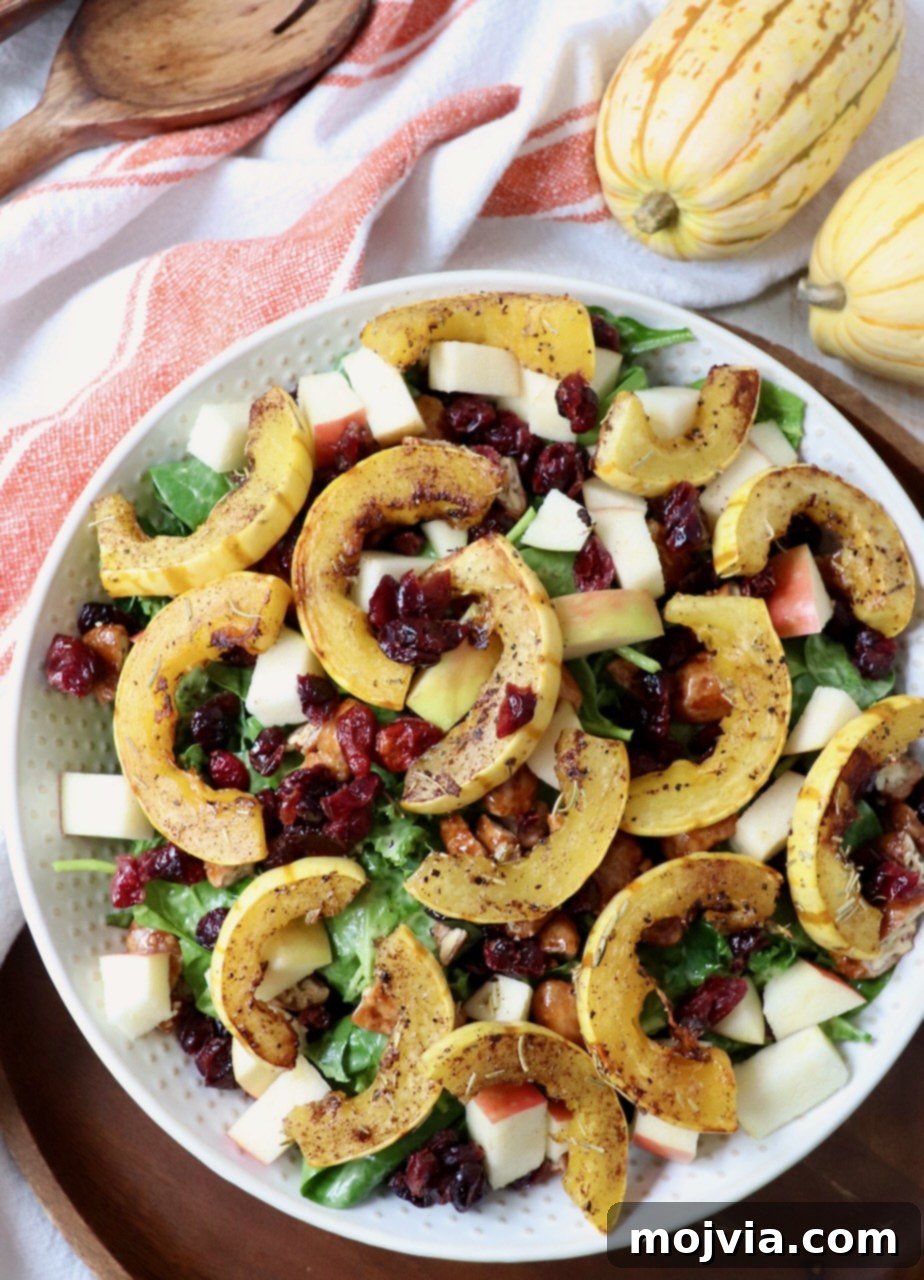Roasted Delicata Harvest Bowl 5 roasted slices of delicata squash on top of salad in large bowl
