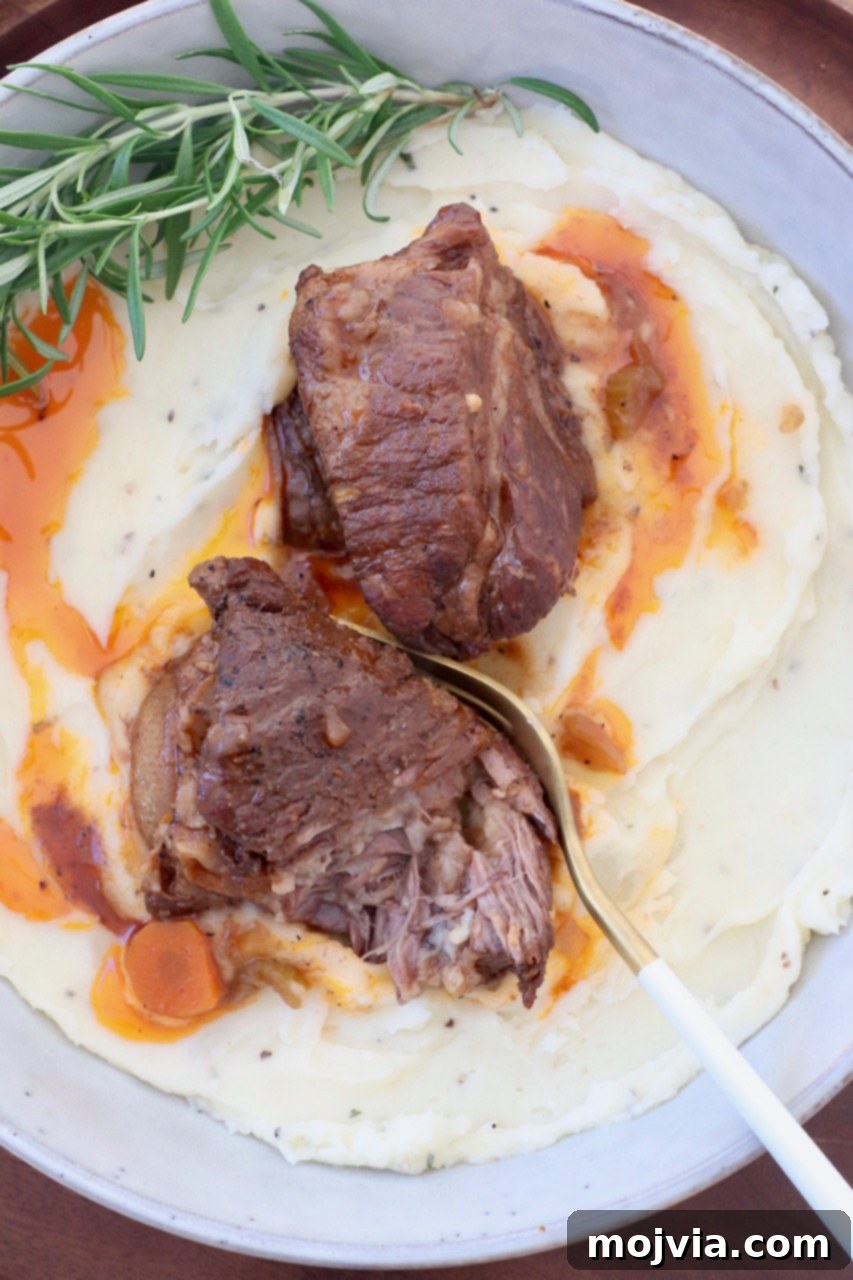 Melt-Off-The-Bone Guinness Short Ribs 11 braised short ribs in bowl with mashed potatoes and fresh rosemary