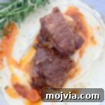 Melt-Off-The-Bone Guinness Short Ribs 13 braised short ribs in bowl with mashed potatoes and fresh rosemary