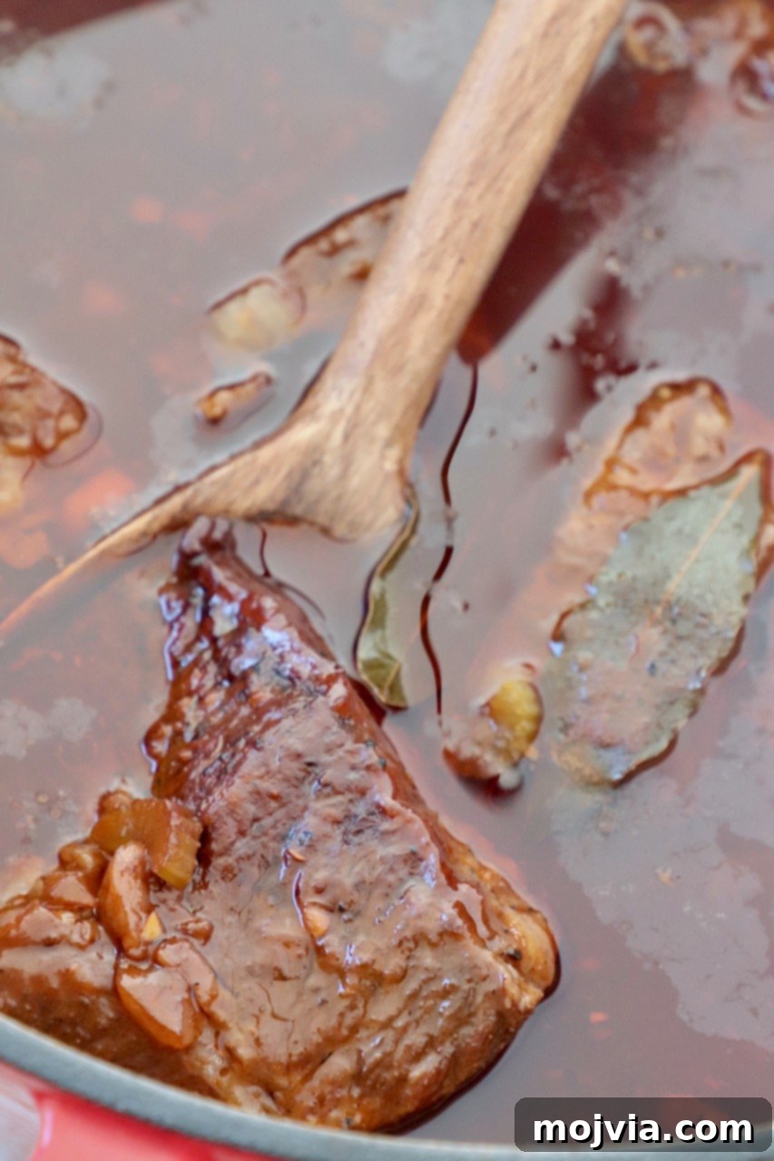 Melt-Off-The-Bone Guinness Short Ribs 10 braised short ribs in dutch oven with serving spoon