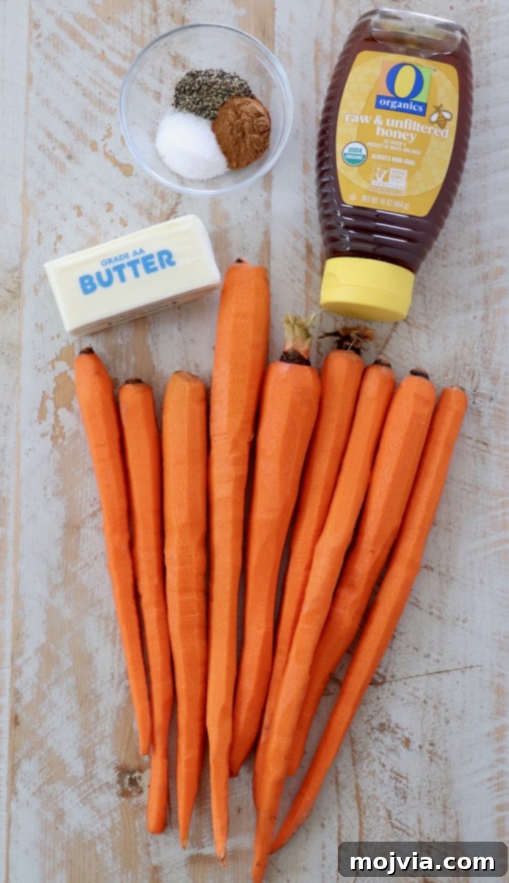 Raw carrots, butter, honey, and cinnamon artfully arranged on a white wooden board, ready for the honey glaze.