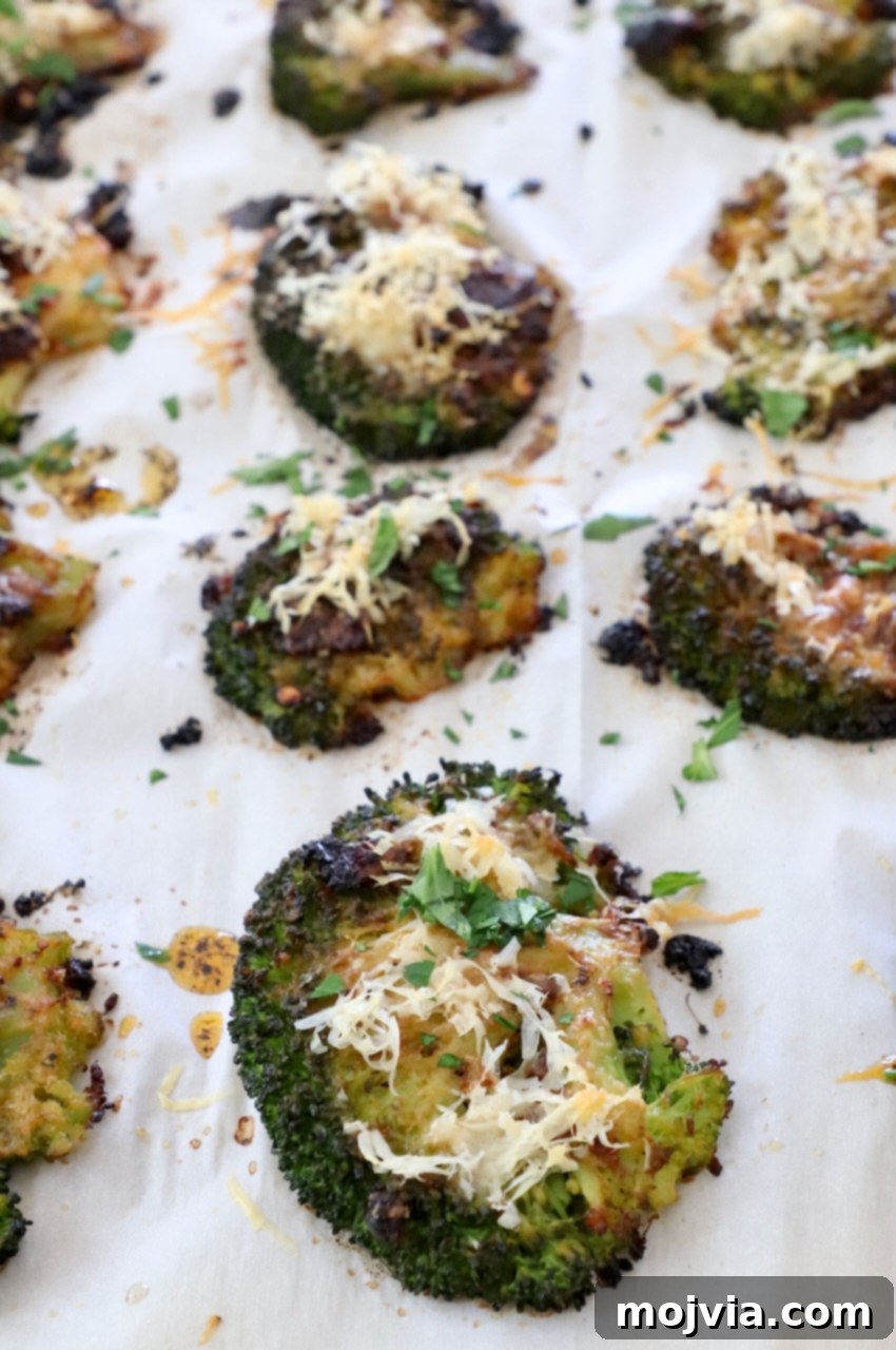 Crispy Smashed Broccoli 10 Golden-brown, roasted smashed broccoli florets on a baking sheet, fresh out of the oven