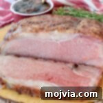 Slow Smoked New York Strip Roast 16 sliced cooked new york strip roast on wood board