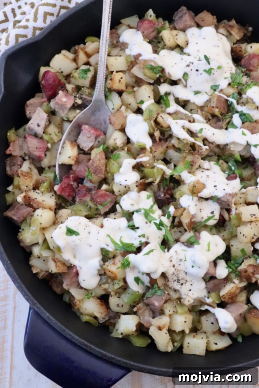 Philly Cheesesteak Skillet 2 diced steak and potato hash in skillet, topped with cheese sauce