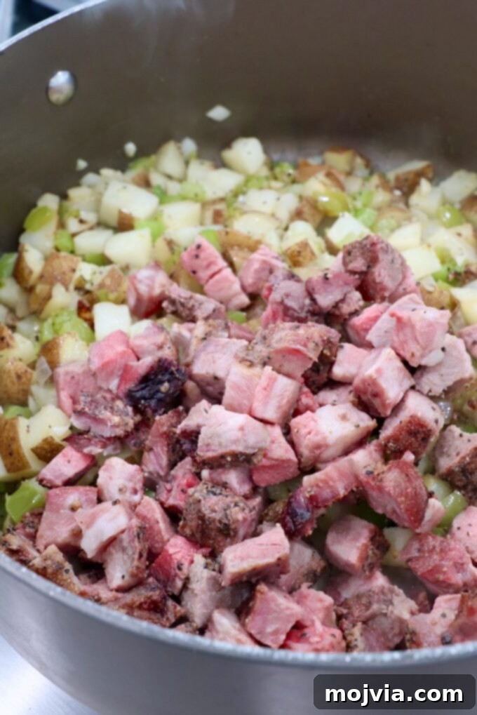 Philly Cheesesteak Skillet 6 cooked, diced steak in dutch oven with potato hash