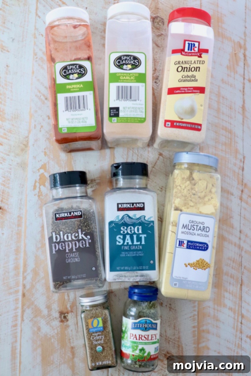 Ultimate Meatloaf Blend 3 Assortment of herbs and spices in plastic containers arranged on a white wooden board