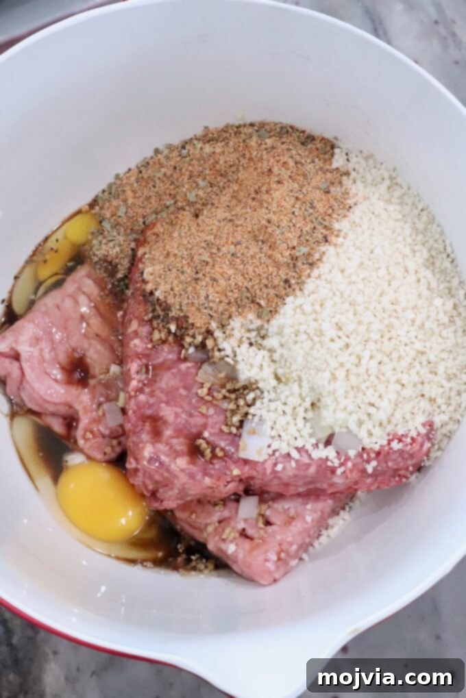 Pitmaster's Smoked Meatloaf 5 ground meat mixture in a large bowl with breadcrumbs, egg, and seasoning