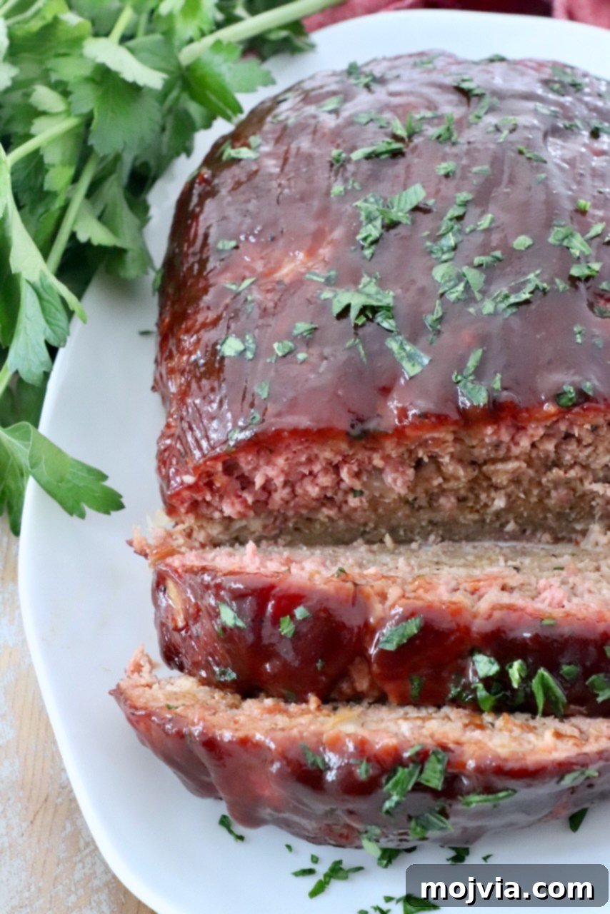 Pitmaster's Smoked Meatloaf 10 glazed smoked meatloaf on plate, sliced to reveal its moist interior
