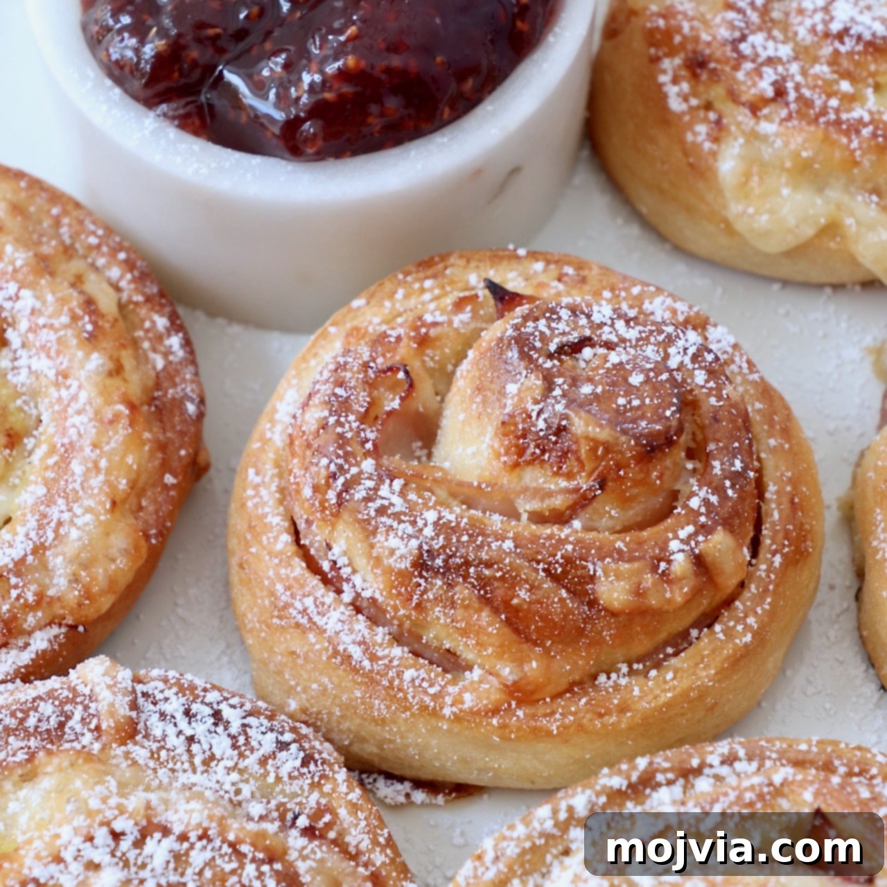 monte cristo rolls on a plate topped with powdered sugar