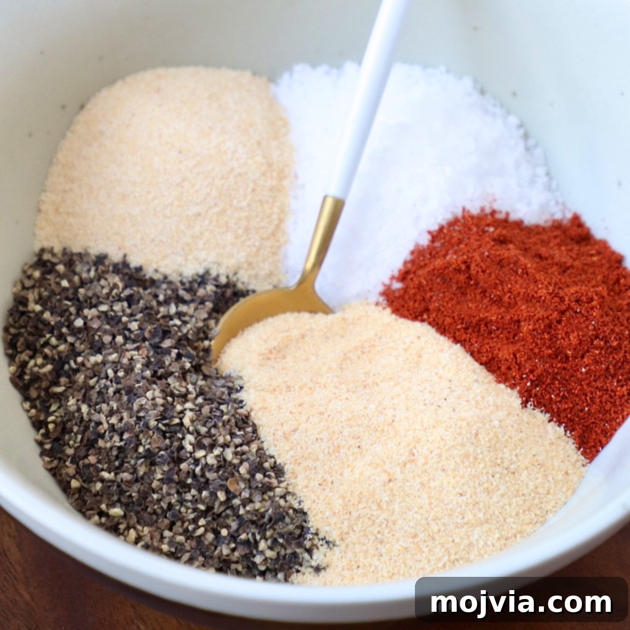 spices in bowl with gold and white spoon