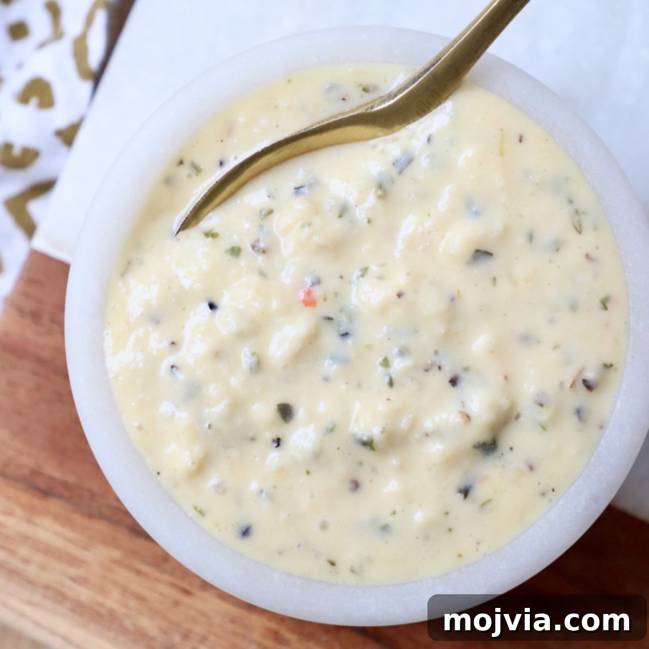 garlic parmesan sauce in bowl with spoon
