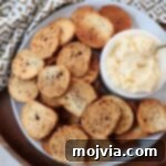Toasted Bagel Crisps 9 A delicious plate of homemade bagel chips served with a small bowl of creamy cheese spread.