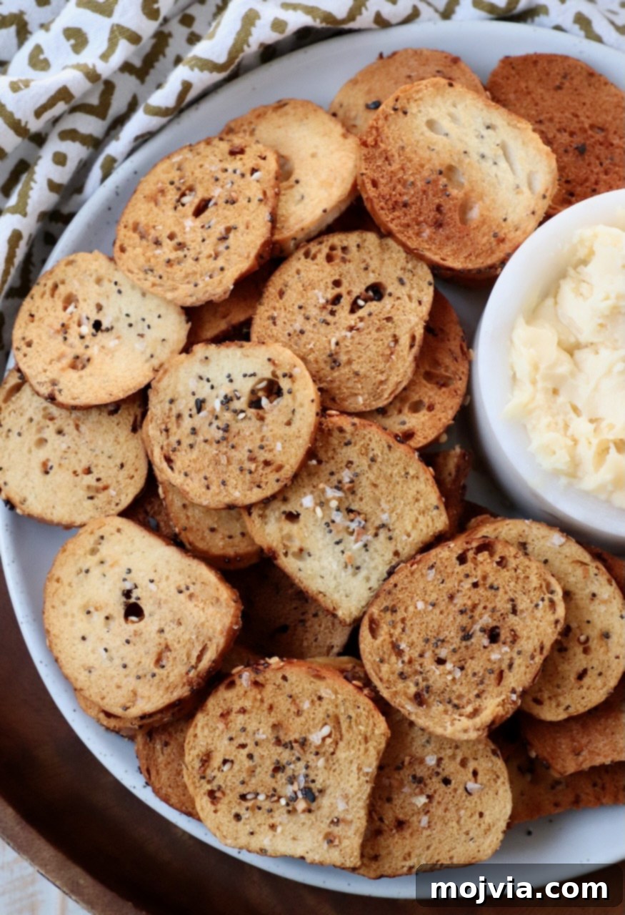 Toasted Bagel Crisps 8 A vibrant plate of everything bagel chips alongside a small bowl of creamy cheddar cheese spread, inviting a delicious snack.