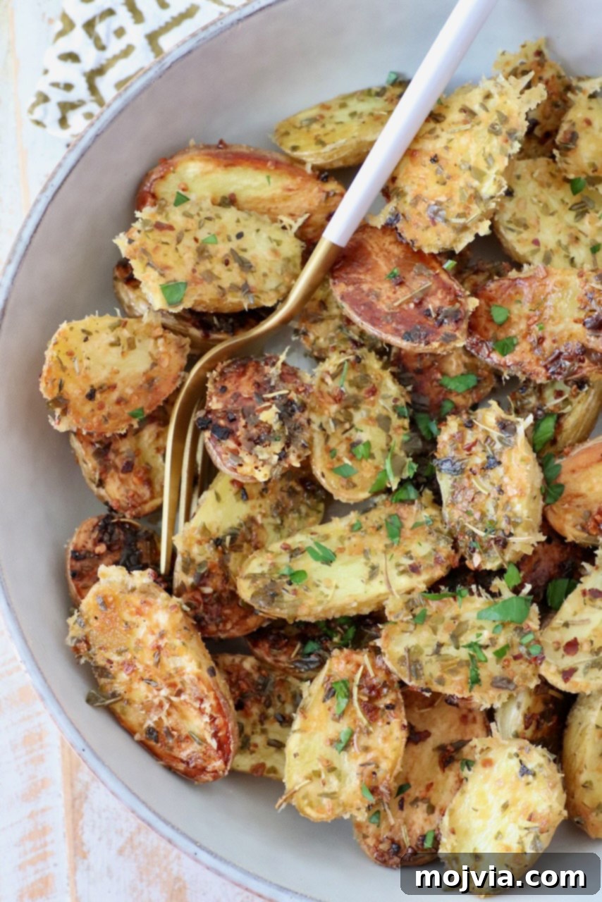 Roasted Small Potatoes 2 A bowl of crispy oven roasted baby potatoes with a fork, ready to be served.