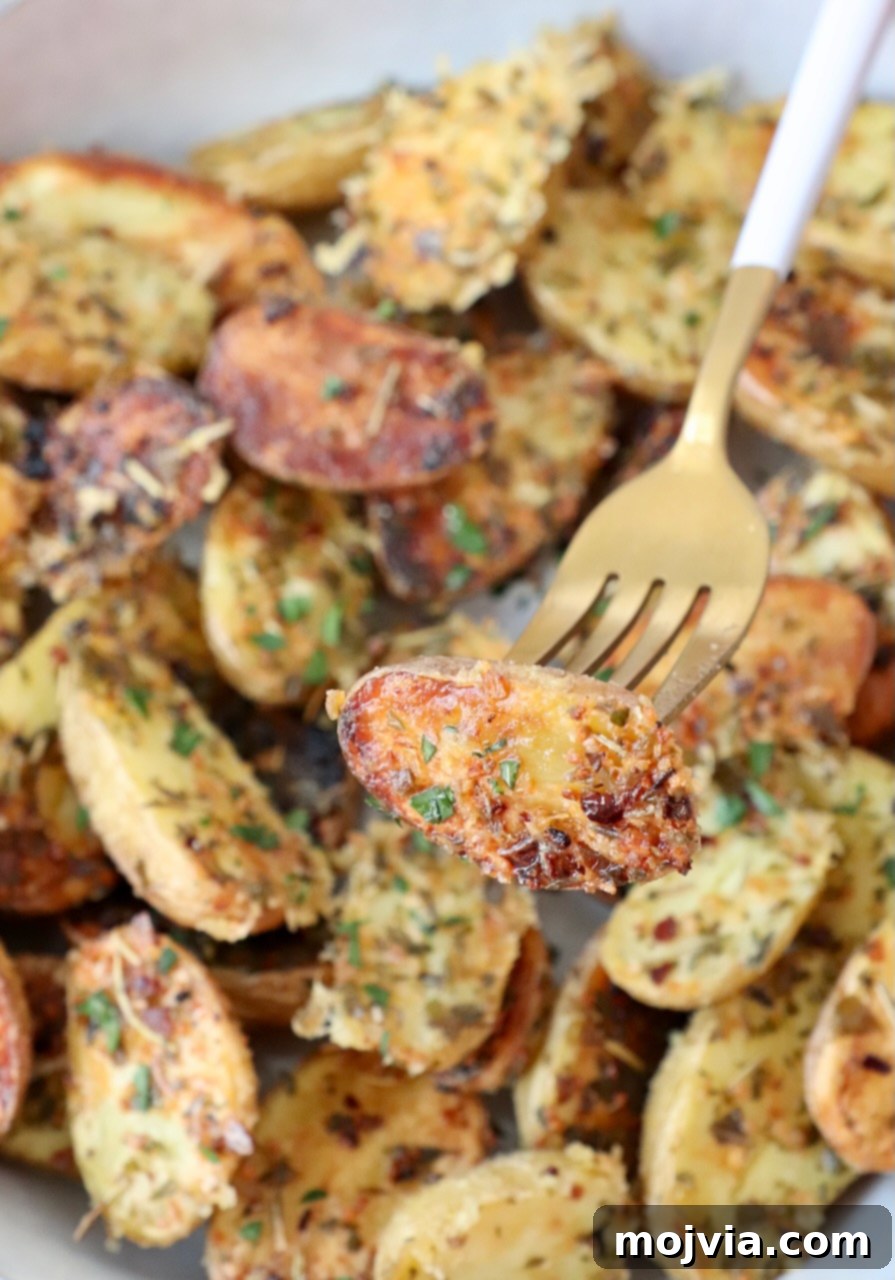 Roasted Small Potatoes 8 A serving of roasted mini potatoes in a bowl, showing their golden brown and crispy texture, with a fork ready to pick one up.