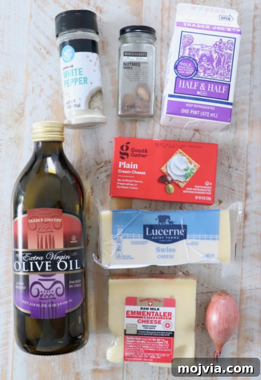 ingredients for cheese fondue on white wood board