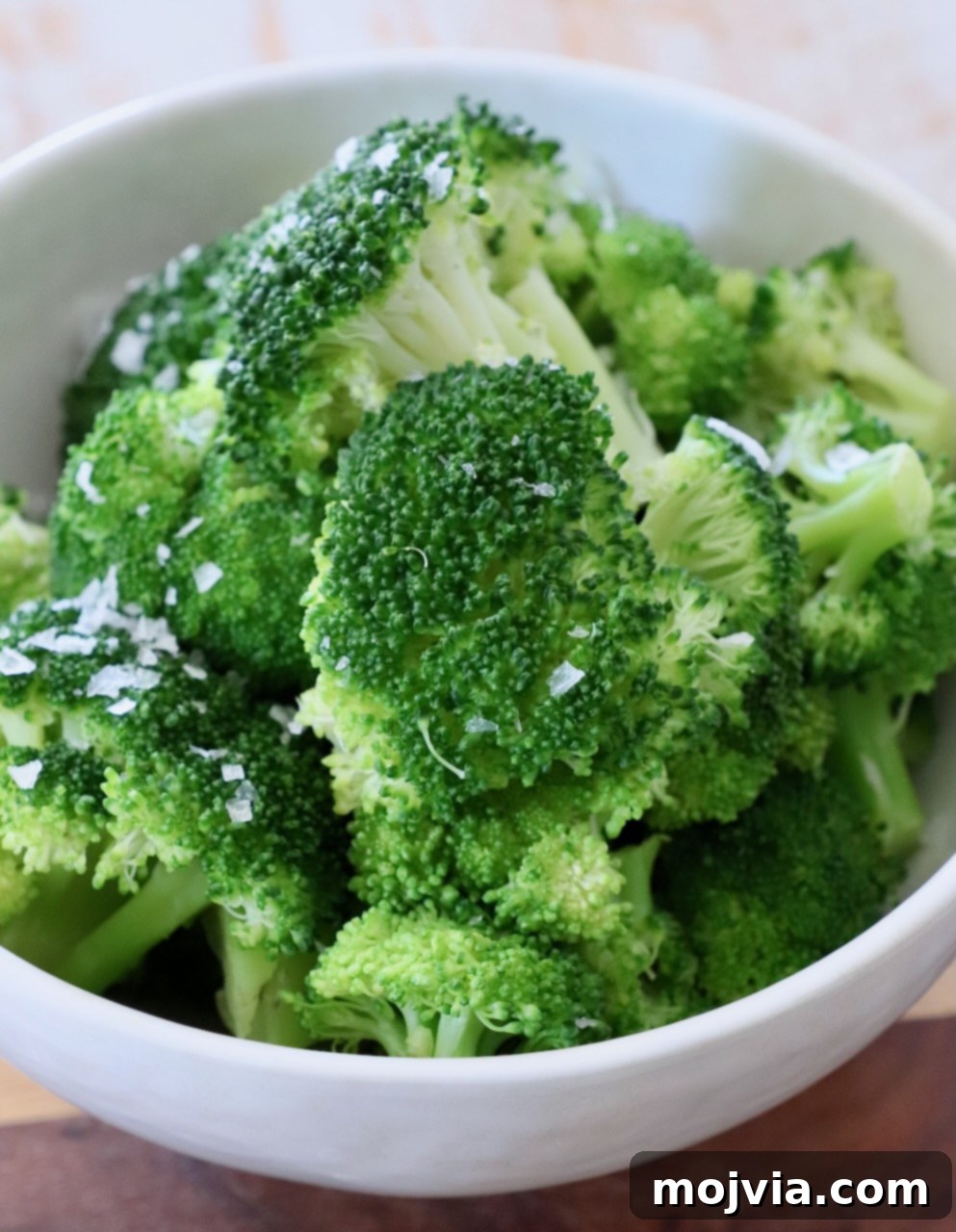 Flawless Steamed Broccoli in Minutes 7 A close-up shot of vibrant green steamed broccoli in a serving bowl, perfectly cooked and ready to be seasoned or served.