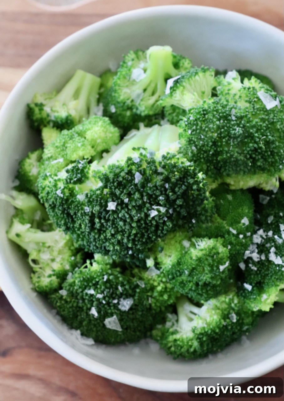 Flawless Steamed Broccoli in Minutes 9 A generous serving of vibrant green steamed broccoli in a bowl, highlighted by natural light, emphasizing its healthy appeal.