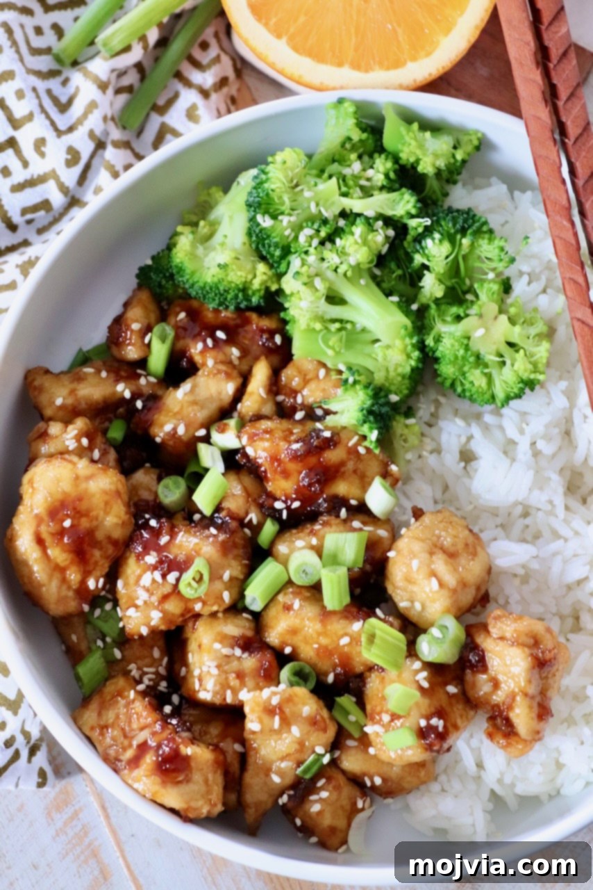 Zesty Orange Glaze 4 A vibrant bowl featuring crispy orange chicken, fluffy white rice, and perfectly steamed broccoli, all drizzled with homemade orange sauce.