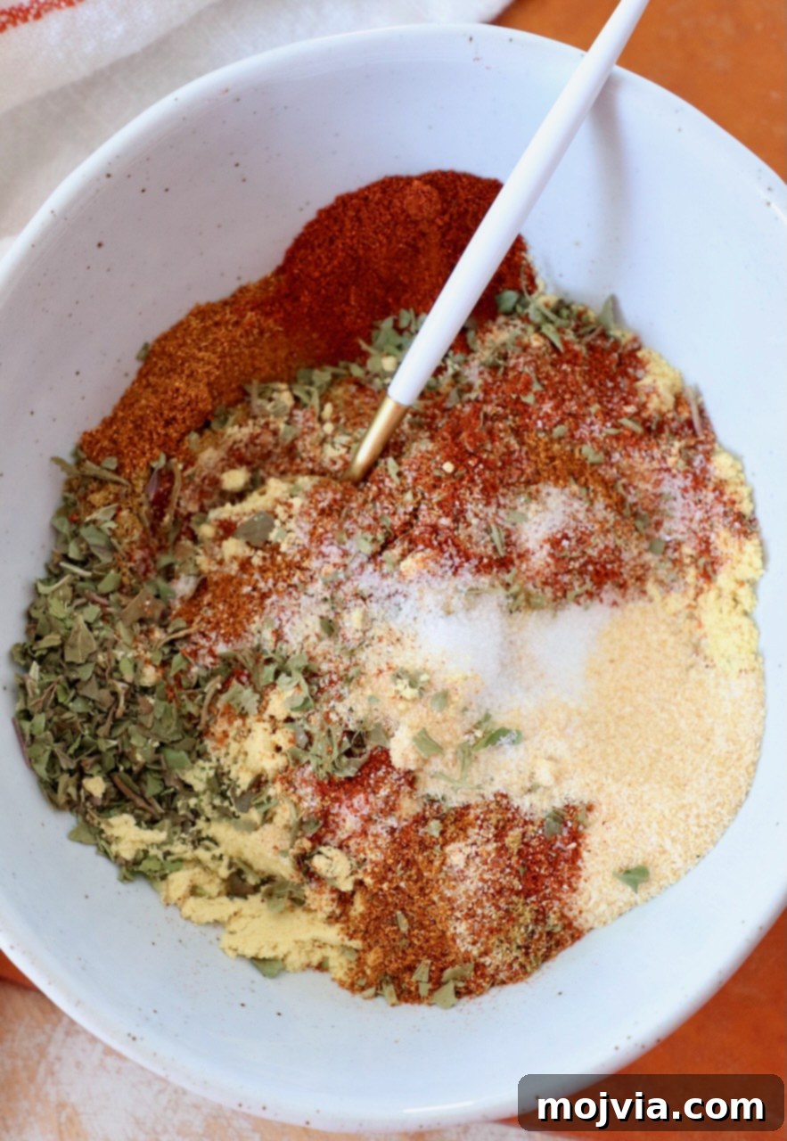 spices and dried herbs mixed together in bowl with spoon