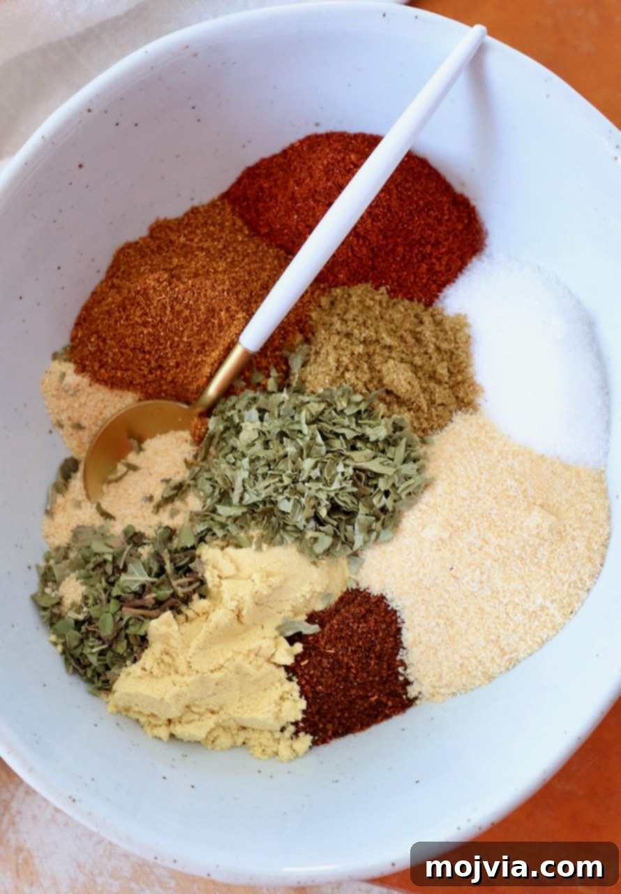 dried herbs and spices separated in bowl with spoon