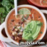 Zesty Southwest Black Bean Soup 10 soup in bowl with spoon and sliced avocado on top