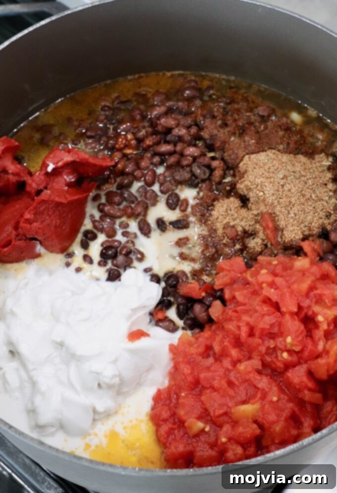Zesty Southwest Black Bean Soup 6 black beans in pot on the stove with coconut milk, diced tomatoes, tomato paste and spices