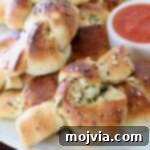 Freshly baked garlic knots on a white plate, ready to be served.