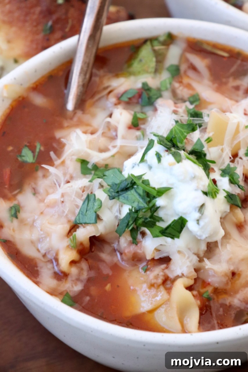 Hearty Lasagna Soup 11 lasagna soup topped with ricotta cheese in bowl with soup