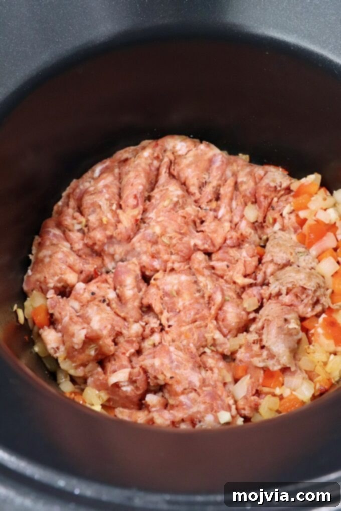 Hearty Lasagna Soup 5 loose Italian sausage in pot with diced vegetables