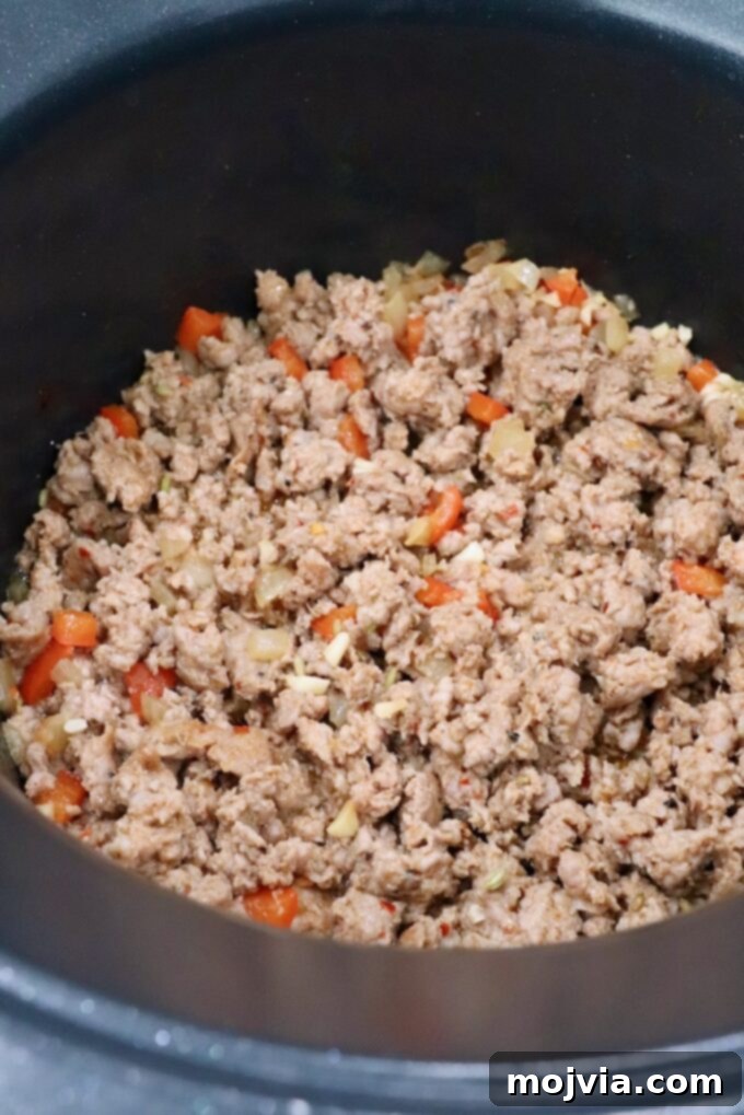 Hearty Lasagna Soup 6 cooked Italian sausage in pot with diced vegetables