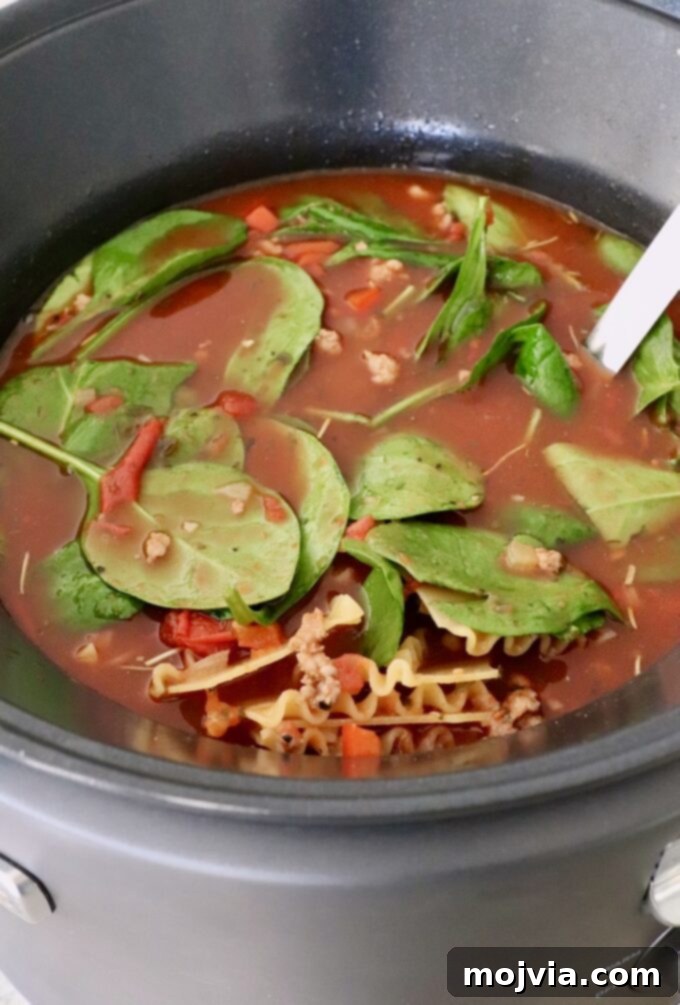 Hearty Lasagna Soup 9 fresh spinach leaves and lasagna noodles in soup in a slow cooker