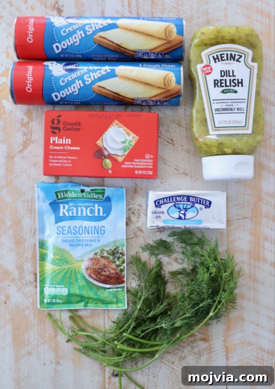 ingredients for creamy pickle roll ups on white wood board