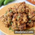 Mexican Chorizo Bisquick Sausage Balls on yellow plate with jalapenos and shredded cheddar cheese