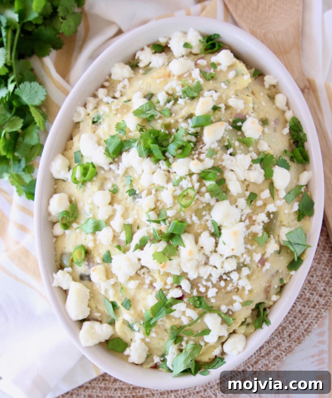 Bowl of mashed potatoes topped with queso fresco, cilantro and green onions