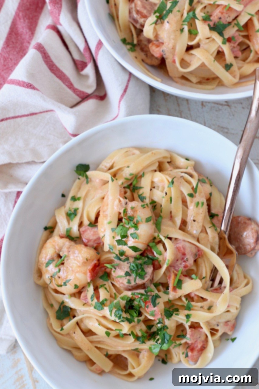 Spicy Cajun Shrimp and Sausage Pasta 5 overhead image of cajun shrimp pasta in white bowls with fork