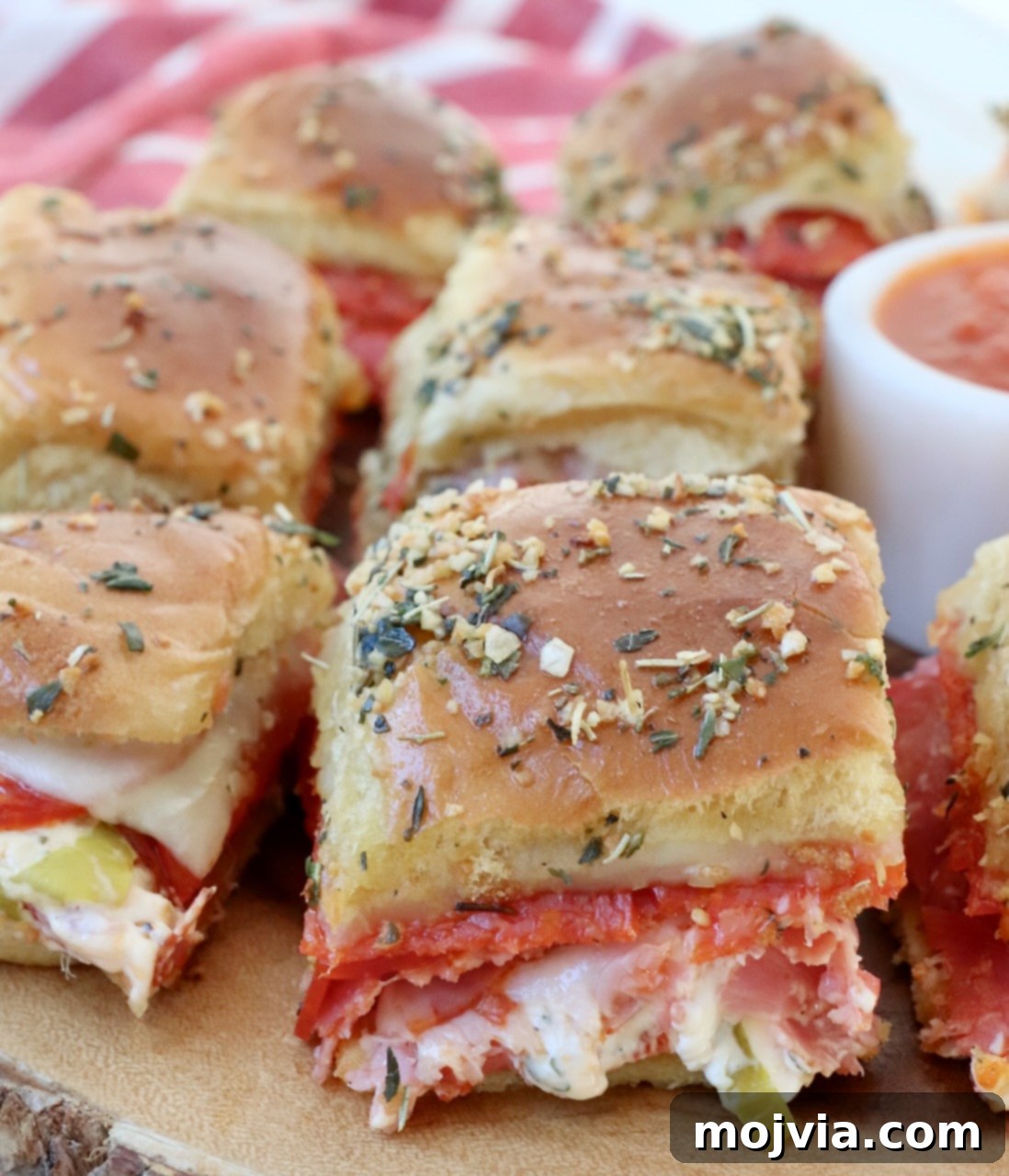 Hot Italian sliders arranged on a wooden serving tray, ready to be enjoyed by a crowd.