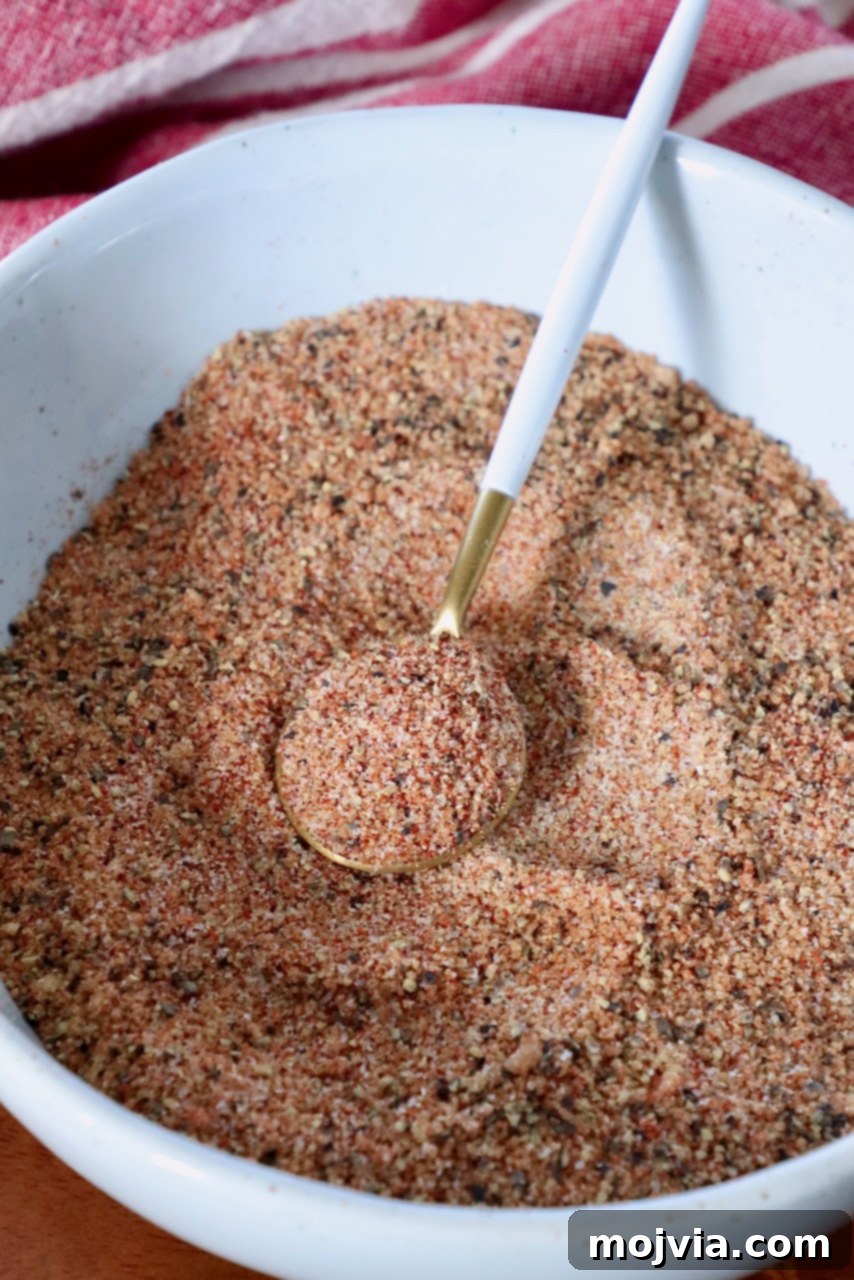 Dry rub for ribs in a bowl with a spoon, highlighting its texture and color