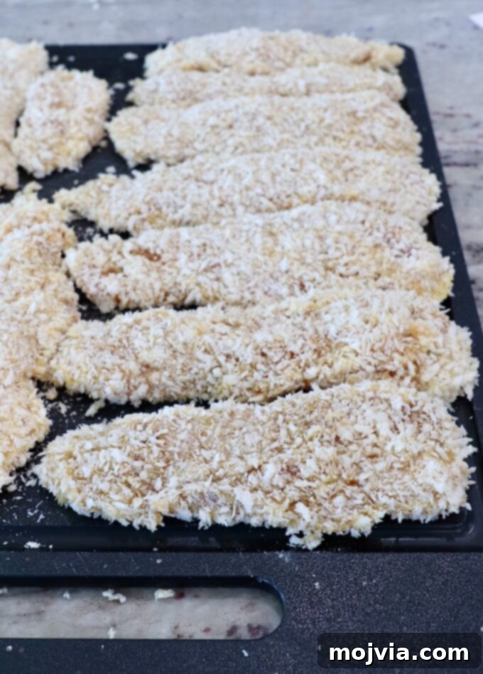 Golden Crispy Air Fryer Chicken 9 breaded chicken strips on cutting board