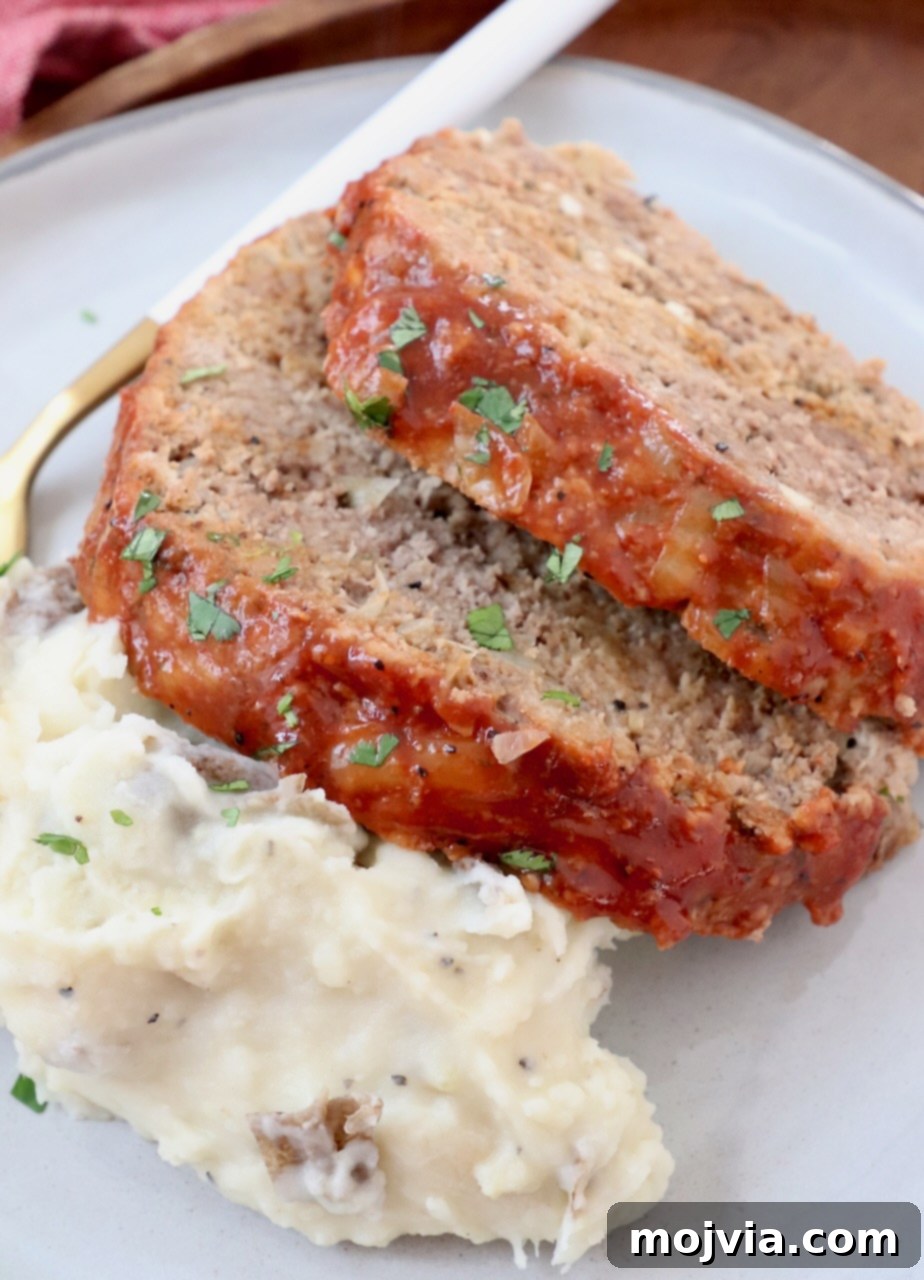 two slices of meatloaf on a plate with mashed potatoes